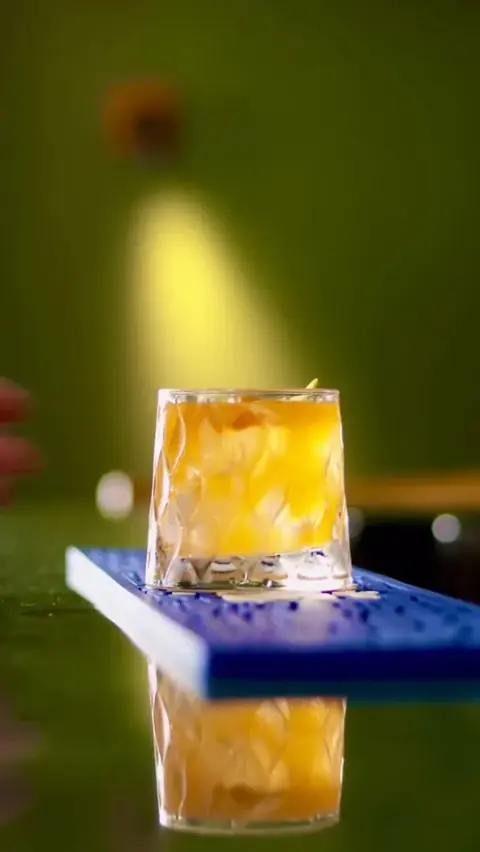 Drink âmbar com gelo em copo baixo